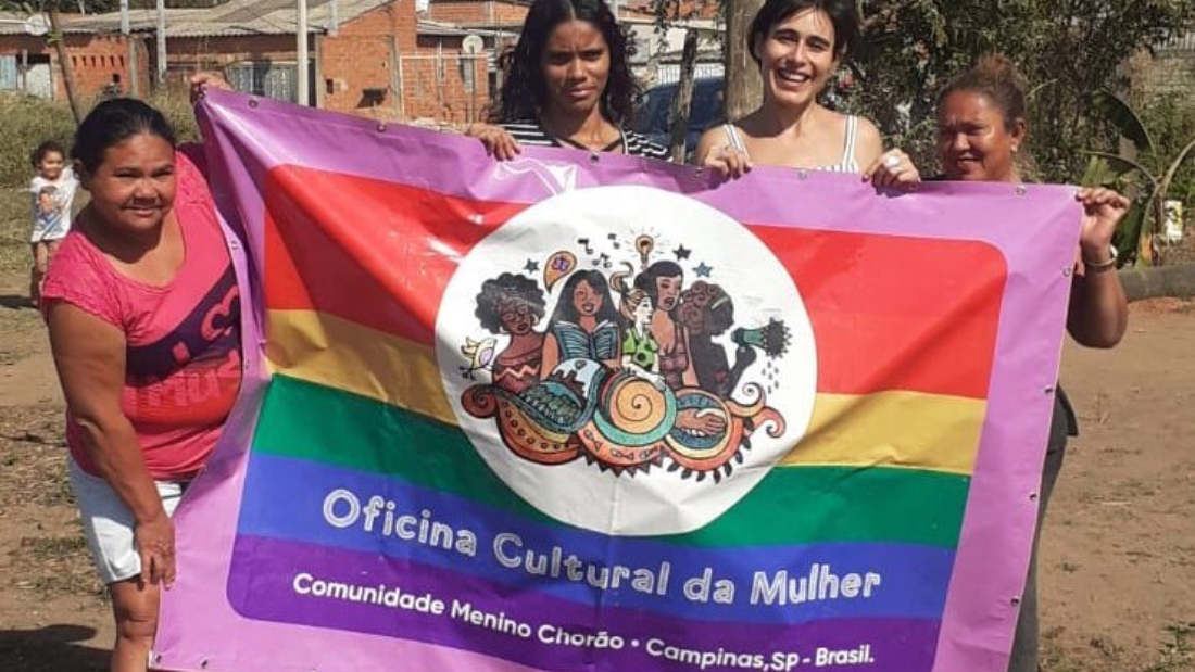 Dona Maria, Aninha, Julia e Carmem com a bandeira da Oficina Cultural da Mulher que acontece na comunidade.
Imagem de Alicia Sei